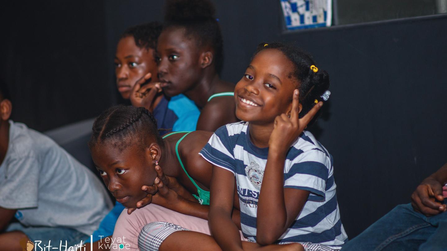 a group of people sitting and looking at the camera