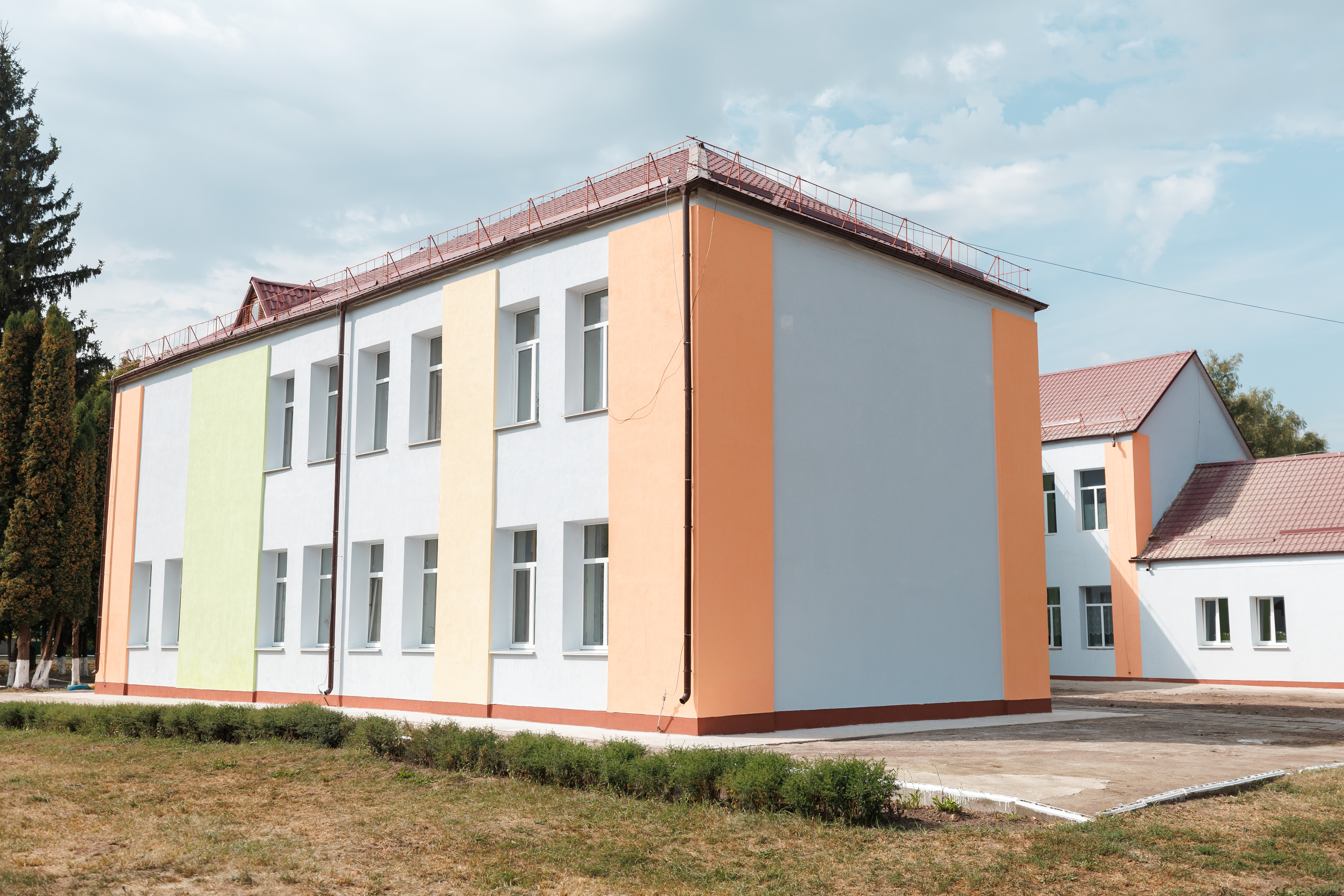 a large brick building with grass in front of a house